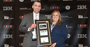 Patrick O'Leary (left) and Tara Bodine from UniFirst accept the Leadership 500 Excellence Award for the UniFirst Management Institute development program.