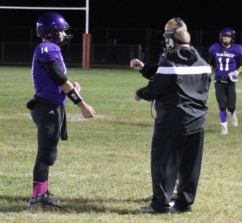 Senior quarterback Alex Tate (14) talks to some of his coaches during Saturday night’s win over Whittier under the lights at Shawsheen Tech. 